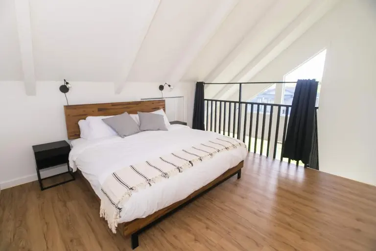 Loft bedroom overlooking the living area in Tidal House Chalet 1.