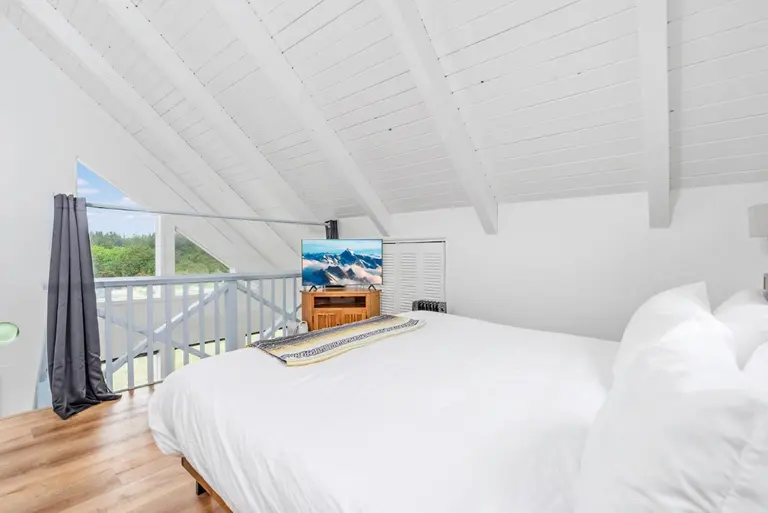 Loft bedroom beside the balcony in Tidal House Chalet 2.