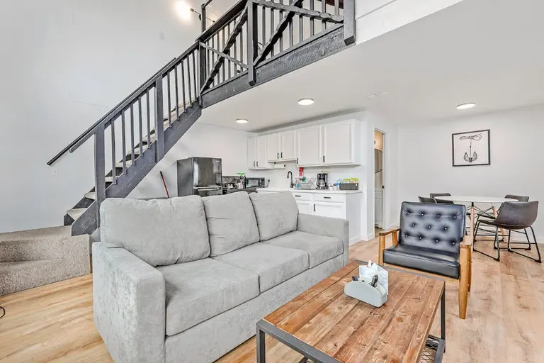 Living room, staircase, and dining area in Tidal House Chalet 3.