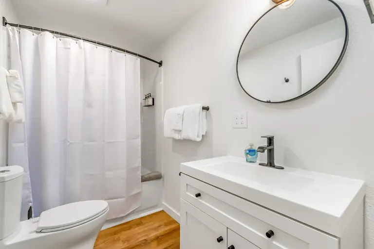 Bathroom with a tub and vanity in Tidal House Chalet 7.
