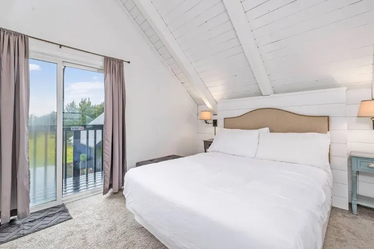 Loft bedroom beside the balcony in Tidal House Chalet 9.