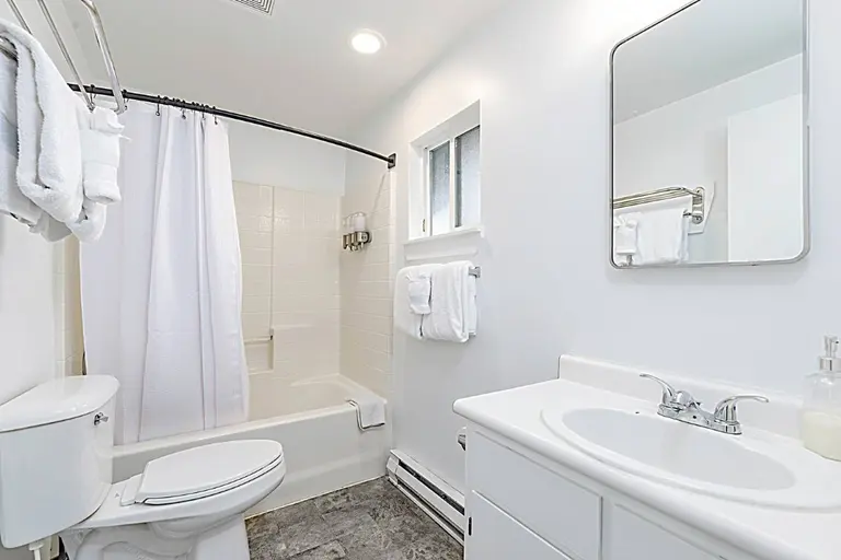 Bathroom with a tub and vanity in Tidal House Chalet 9.