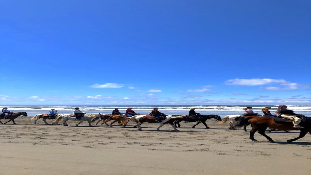 Group of riders on horseback along the Pacific Ocean beach in Ocean Shores, Washington